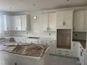Spacious kitchen with white cabinets, a tile backsplash, quartz counters, and stainless steel appliances at 253 Tidal Pool Way, Cary, NC 27519
