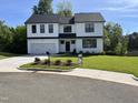 Beautifully landscaped two-story home with black trimmed windows, a white exterior, and a lovely green lawn at 3204 Overlook Ct, Burlington, NC 27215