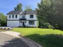 New home boasting well-manicured landscaping and a sleek black and white exterior, complemented by mature trees at 3204 Overlook Ct, Burlington, NC 27215