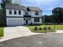 Eye-catching two-story house showcasing a lush green lawn, contemporary black-and-white color palette, and mature trees at 3204 Overlook Ct, Burlington, NC 27215