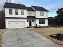 Striking two-story home with modern white siding, black trim, attached two-car garage, and a concrete driveway at 3204 Overlook Ct, Burlington, NC 27215