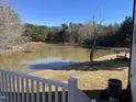 A view of the pond with a white deck railing in the lower left of the shot at 3204 Overlook Ct, Burlington, NC 27215