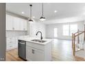 Modern kitchen with white cabinetry, stainless steel appliances, and a central island overlooking the living area at 343 Church St # 66, Wendell, NC 27591