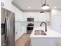 Contemporary kitchen with stainless steel appliances, white cabinets, and a functional center island at 343 Church St # 66, Wendell, NC 27591