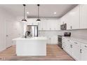 Stylish kitchen with white cabinets, stainless steel appliances, and a convenient island layout at 343 Church St # 66, Wendell, NC 27591