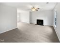 Open-concept living room with fireplace, neutral carpet, and ample natural light at 3604 Tunas St, Raleigh, NC 27616