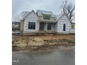 New home under construction, with yellow siding, large windows, and a view of the pond in the back at 395 Meadow Walk Dr, Fuquay Varina, NC 27526