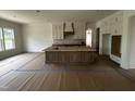 View of kitchen island, hood vent and cabinets with view to side pantry in new construction home at 395 Meadow Walk Dr, Fuquay Varina, NC 27526