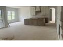 Spacious kitchen area with white cabinets and a gray kitchen island under construction at 395 Meadow Walk Dr, Fuquay Varina, NC 27526