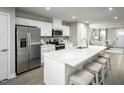 Modern kitchen with white cabinetry, stainless steel appliances, and a spacious center island at 429 Grand Silo Rd, Raleigh, NC 27603