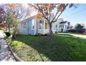 View of the light blue house with white trim and yellow front door, showcasing the tidy front lawn at 518 Worth St, Raleigh, NC 27601