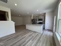 Open concept kitchen with granite countertops, gray cabinetry, stainless steel appliances, and wood-look flooring at 6132 Arsenal Ave, Raleigh, NC 27610