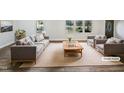 Staged living room featuring neutral furniture, modern decor, and plenty of natural light at 6423 Whitt Rd, Durham, NC 27712