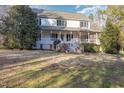 Inviting two-story home featuring a classic covered porch and mature landscaping at 69 Holly Tree Dr, Timberlake, NC 27583
