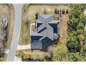 An aerial view of the home with a gray roof, surrounded by a driveway, mature trees, and landscaping at 1013 Timber Mist Ct, Cary, NC 27519