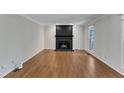 Bright living room featuring hardwood floors and a traditional black fireplace at 1031 Wait Ave, Wake Forest, NC 27587