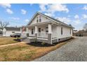 Charming white home featuring a cozy front porch and mature landscaping at 111 N Marshall St, Graham, NC 27253