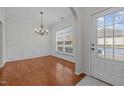 Bright dining area featuring hardwood floors, elegant chandelier, and classic wainscoting for a sophisticated touch at 11425 Shadow Elms Ln, Raleigh, NC 27614