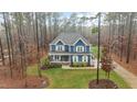 Aerial view of a blue two-story home with a covered front porch surrounded by trees at 130 Willow Bend Dr, Youngsville, NC 27596