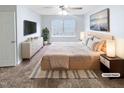 Staged bedroom with a plush rug, king bed, and a large window providing ample natural light at 1628 Beacon Village Dr, Raleigh, NC 27604