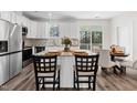 Eat in kitchen features stainless steel appliances, granite countertops, white cabinetry, and a breakfast bar at 1915 Lambert Rd, Graham, NC 27253
