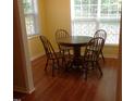 Cozy dining area featuring a round wooden table, four chairs, and natural light from the windows at 2000 University Woods Rd # 201, Raleigh, NC 27603