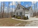 Well-maintained gray home exterior featuring an attached garage and tasteful landscaping at 2482 Golden Forest Dr, Franklinton, NC 27525