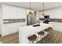 Bright, open kitchen featuring white cabinets, stainless steel appliances, and a large island at 249 Beacon Dr, Pittsboro, NC 27312