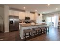 Bright kitchen featuring an island with granite countertops, a stainless steel refrigerator, and seating for four at 306 Brier Summit Pl, Durham, NC 27703