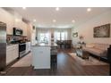A kitchen with a spacious island adjoins a living area and dining room, with abundant natural light at 306 Brier Summit Pl, Durham, NC 27703