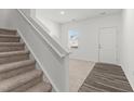 Bright entryway showcasing stairs, neutral carpet, and wood-look vinyl flooring at 40 Rolling Banks Dr, Louisburg, NC 27549