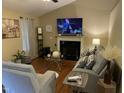 Cozy living room featuring a fireplace, hardwood floors, and stylish decor at 421 Angus Pl, Stem, NC 27581