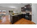 Modern kitchen featuring dark cabinets, granite countertops, and stainless steel appliances at 532 Smithridge Way, Fuquay Varina, NC 27526