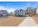 Spacious two-story home with a long driveway and well-manicured lawn, offering ample parking and curb appeal at 594 Executive Dr, Lillington, NC 27546