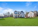Charming two-story home showcasing a lush front lawn, neutral siding, and blue shutters at 594 Executive Dr, Lillington, NC 27546