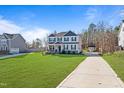 Beautiful two-story house with a well-maintained lawn and a long driveway at 594 Executive Dr, Lillington, NC 27546
