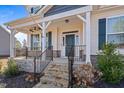 Inviting front porch with stone steps, iron railings, and elegant columns, creating a welcoming entrance at 594 Executive Dr, Lillington, NC 27546