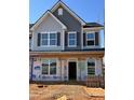 Two-story home featuring large windows, shutters, and a covered front porch during construction phase at 945 Alma Railway Dr # 559, Wake Forest, NC 27587