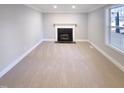 Cozy living room featuring a fireplace, carpet flooring, and plenty of natural light at 101 Madeline Ct, Youngsville, NC 27596