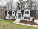 Charming two-story home featuring a symmetrical facade, black roof, and white brick exterior at 109 Chatterson Dr, Raleigh, NC 27615