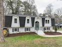 Charming two-story home featuring a symmetrical facade, black roof, and white brick exterior at 109 Chatterson Dr, Raleigh, NC 27615