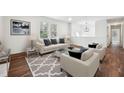 Bright living room with neutral furniture, a large window, and hardwood floors at 109 Chatterson Dr, Raleigh, NC 27615
