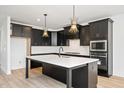 Contemporary kitchen with black cabinetry, stainless appliances, and a spacious island at 1205 Porters Call Dr, Wendell, NC 27591