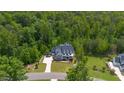 Stunning aerial view of a beautifully landscaped property surrounded by lush green trees and a winding driveway at 175 Stonecrest Way, Pittsboro, NC 27312