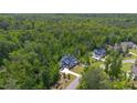 Aerial shot of a neighborhood home surrounded by mature trees with a winding driveway and landscaping at 175 Stonecrest Way, Pittsboro, NC 27312
