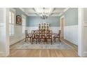 Traditional dining room featuring wainscoting, coffered ceilings, chandelier, and wood floors at 175 Stonecrest Way, Pittsboro, NC 27312