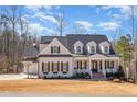 Beautiful suburban home with a covered porch, dormers, a three-car garage, and manicured yard at 175 Stonecrest Way, Pittsboro, NC 27312