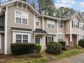 Inviting townhouse with beautiful landscaping, a blue front door, and neutral siding at 2268 Plum Frost Dr, Raleigh, NC 27603