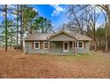 Charming exterior view of home with green siding, front porch, and natural light at 2502 Devils Racetrack Rd, Four Oaks, NC 27524