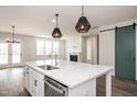 Open-concept kitchen with a large island, stainless steel appliances, and a cozy fireplace nearby at 264 Big Bradley Dr, Wendell, NC 27591
